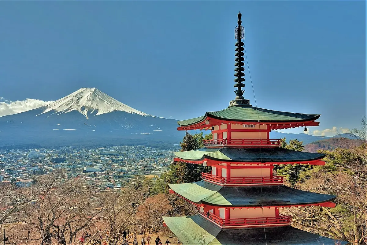 The red five-storey Chureito Pagoda in front of a snow-capped Mount Fuji above the town of Fujiyoshida